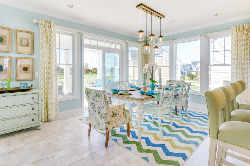 Idee per una sala da pranzo aperta verso il soggiorno stile marinaro con pareti blu e parquet chiaro