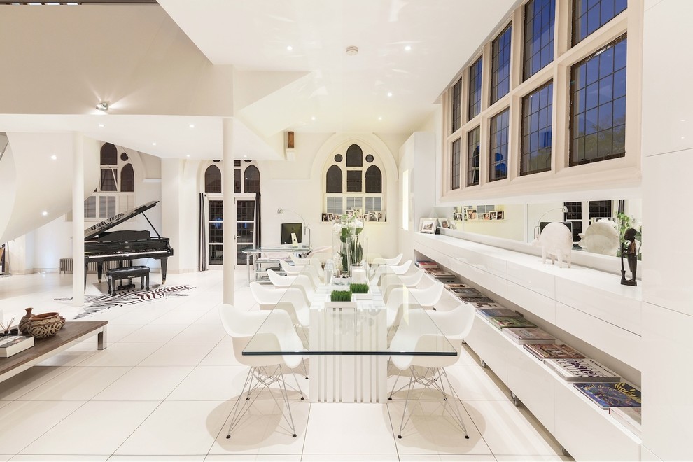 Réalisation d'une salle à manger ouverte sur le salon design avec un mur blanc, aucune cheminée et un sol blanc.