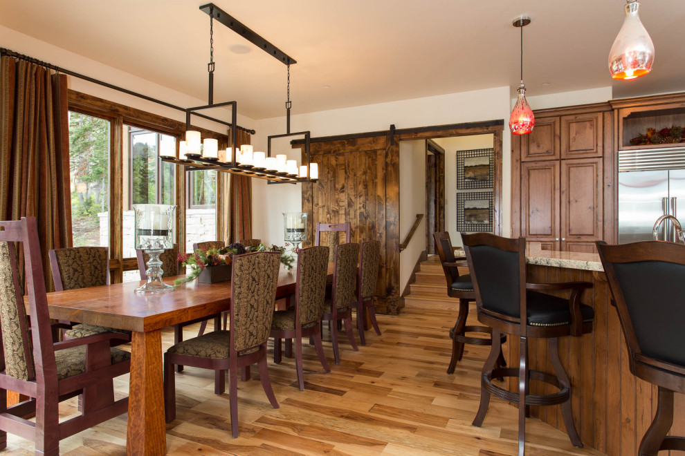 Foto di una grande sala da pranzo aperta verso la cucina stile rurale con pareti beige e parquet chiaro