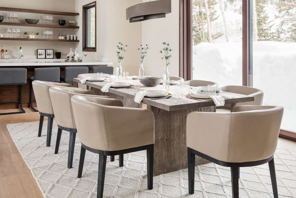 Cette photo montre une salle à manger ouverte sur le salon tendance avec un mur beige, un sol en bois brun et un sol beige.