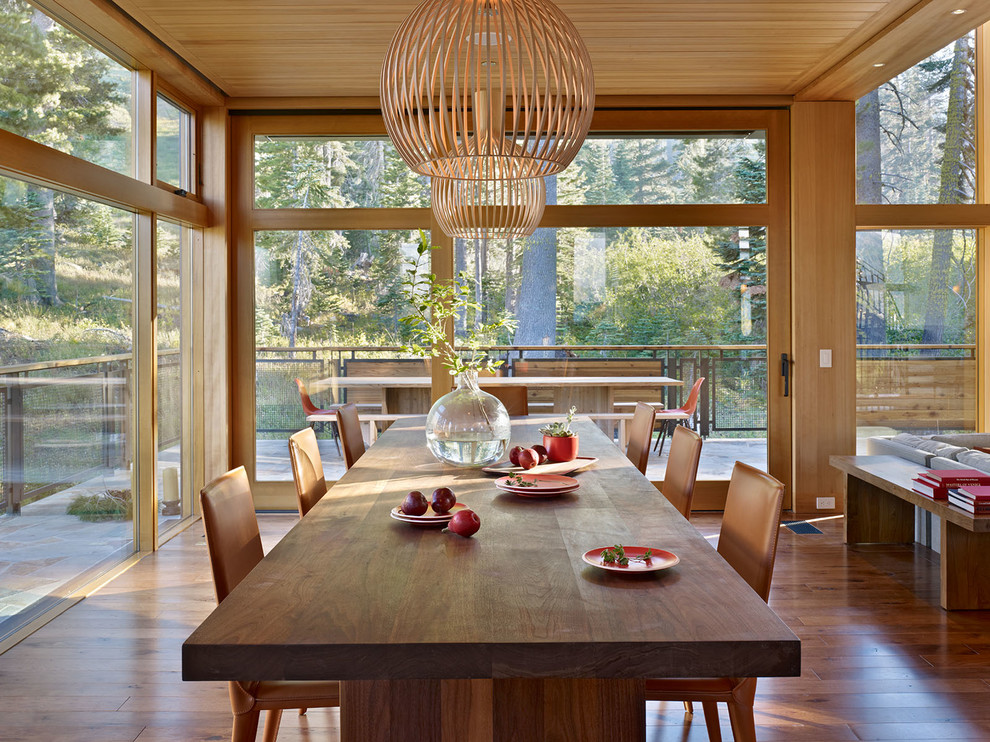 Cette photo montre une grande salle à manger ouverte sur le salon montagne avec un sol en bois brun.