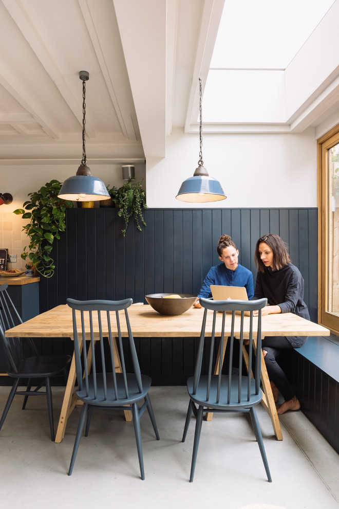 Idee per una sala da pranzo aperta verso la cucina di medie dimensioni con pareti blu, pavimento in cemento e pavimento grigio