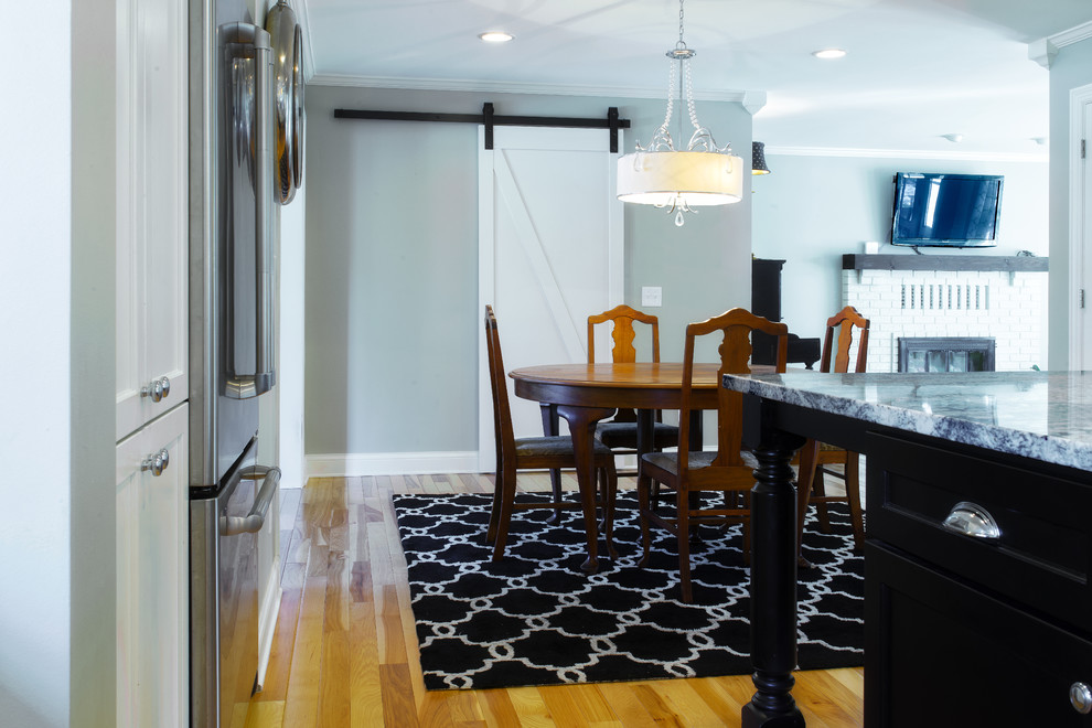 Idées déco pour une salle à manger ouverte sur la cuisine classique de taille moyenne avec parquet clair et un mur gris.
