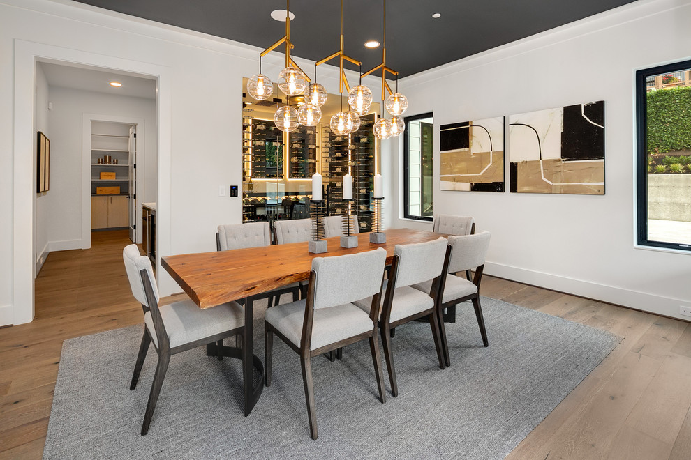 Design ideas for a large contemporary dining room in Seattle with white walls, medium hardwood flooring, grey floors and feature lighting.