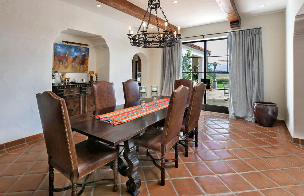 Design ideas for a large mediterranean enclosed dining room in San Luis Obispo with white walls, terracotta flooring, no fireplace and brown floors.