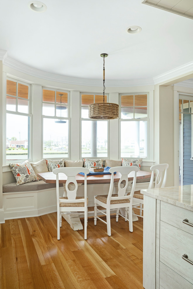 Idee per una sala da pranzo aperta verso la cucina stile marinaro con pareti beige, pavimento in legno massello medio e pavimento marrone