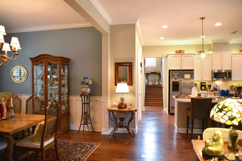Cette photo montre une salle à manger ouverte sur le salon éclectique de taille moyenne avec un mur bleu et parquet foncé.