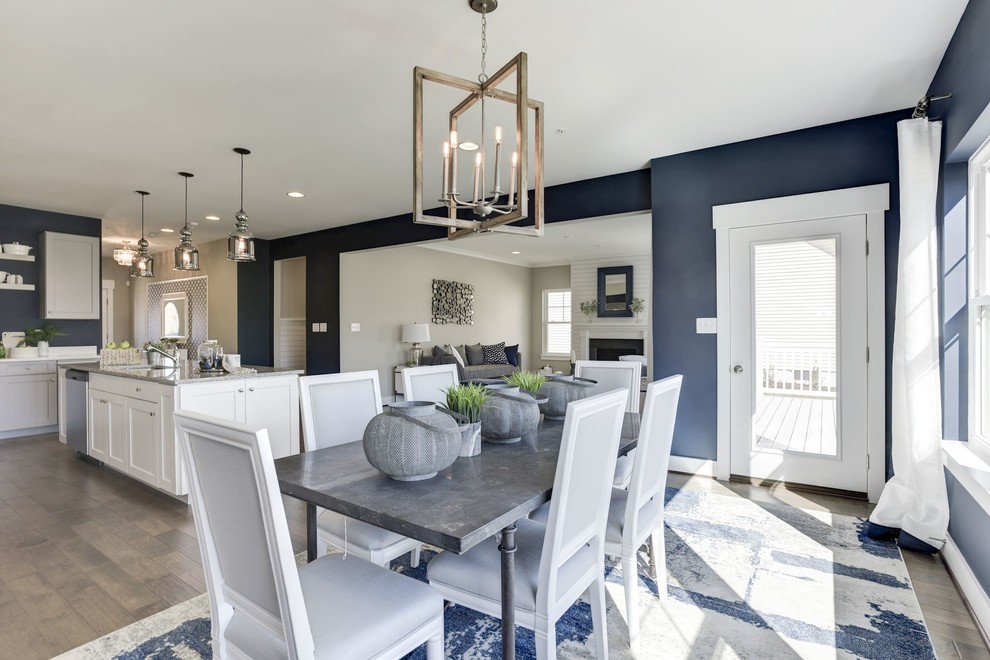 Foto di una sala da pranzo aperta verso la cucina country di medie dimensioni con pareti blu e pavimento in legno massello medio