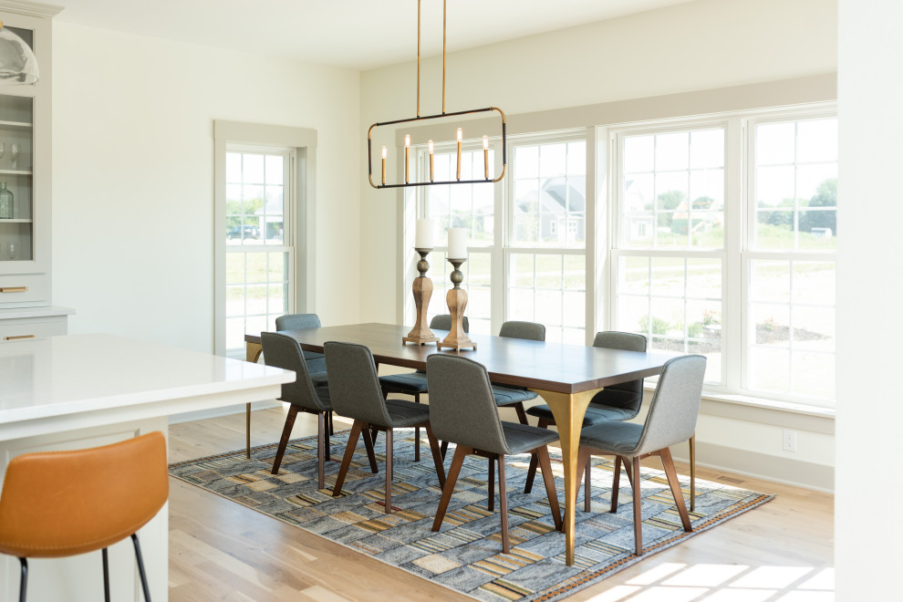Dining room - transitional light wood floor and beige floor dining room idea in Milwaukee with white walls