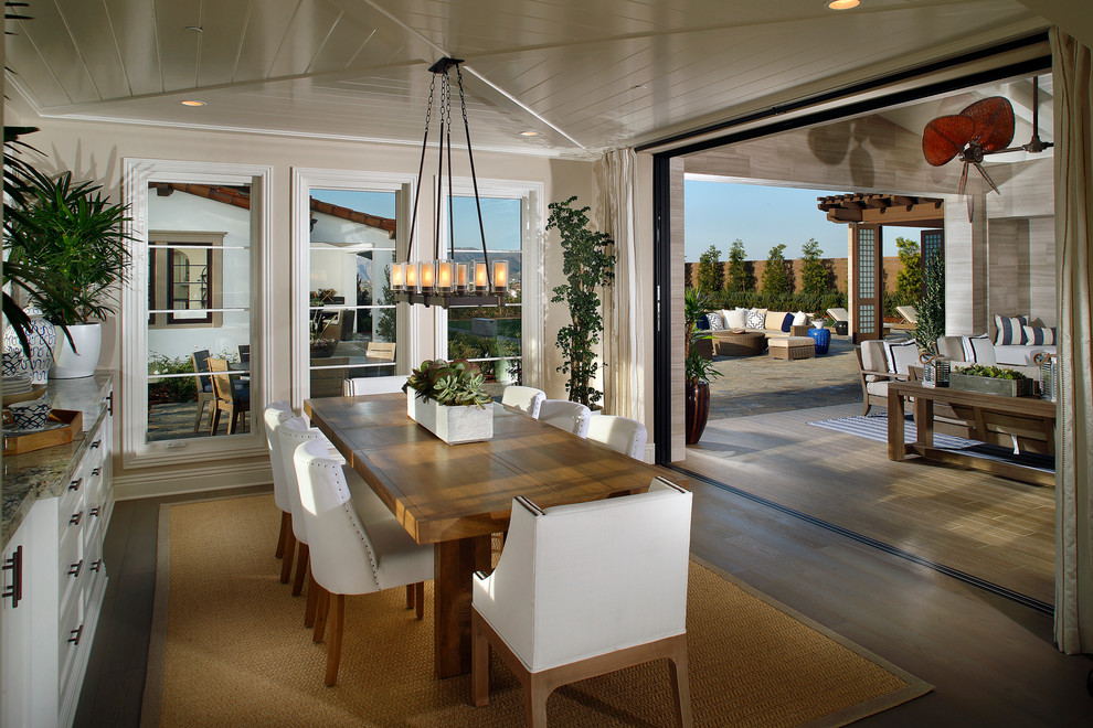 Immagine di un'ampia sala da pranzo aperta verso la cucina costiera con pareti beige, parquet chiaro e nessun camino