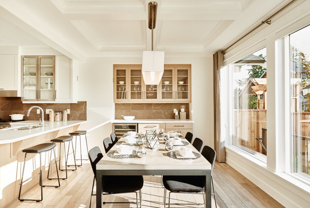 Immagine di una sala da pranzo aperta verso la cucina tradizionale con pareti bianche e parquet chiaro