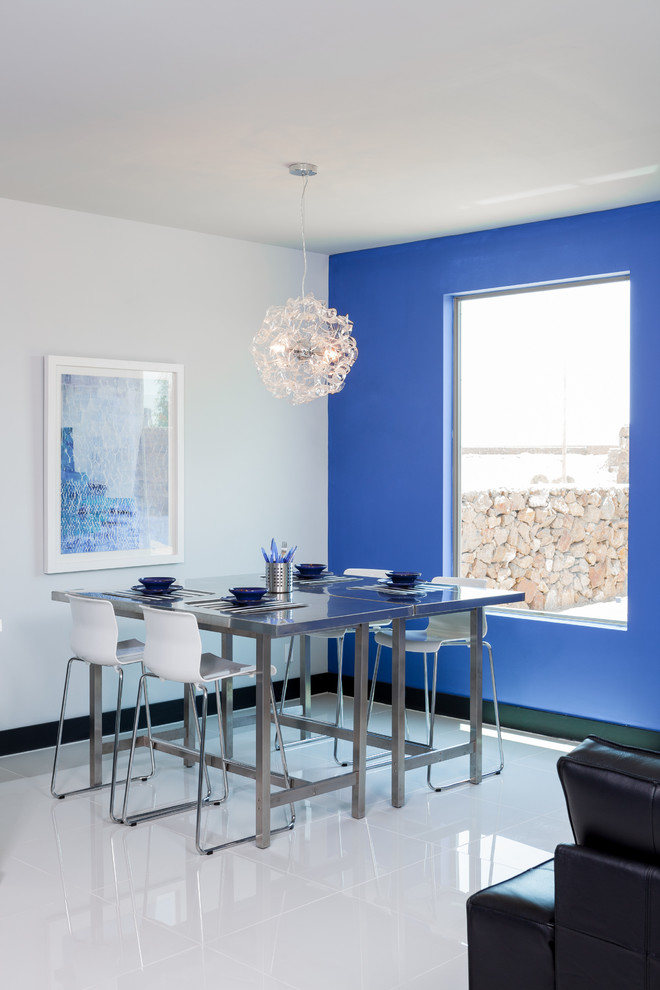 Aménagement d'une salle à manger moderne avec un mur bleu.