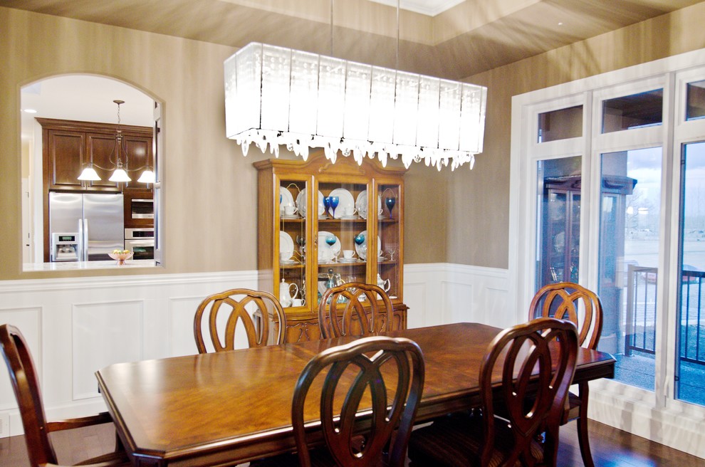 Example of a mid-sized medium tone wood floor enclosed dining room design in Calgary with beige walls