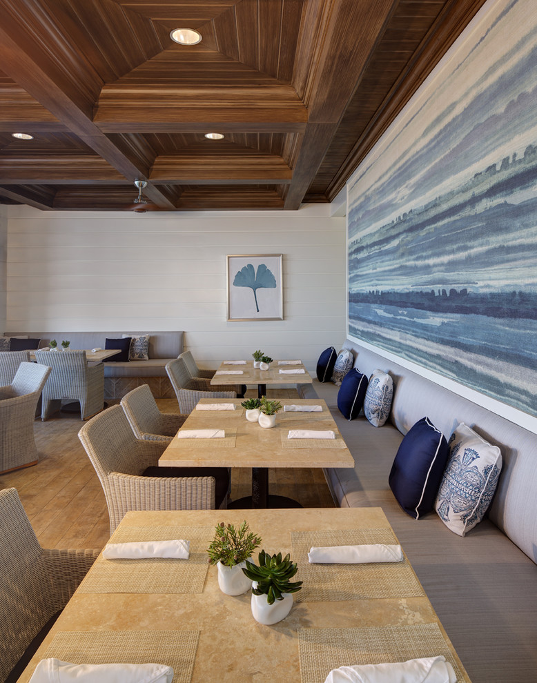 Inspiration for an expansive coastal dining room in Miami with white walls and light hardwood flooring.