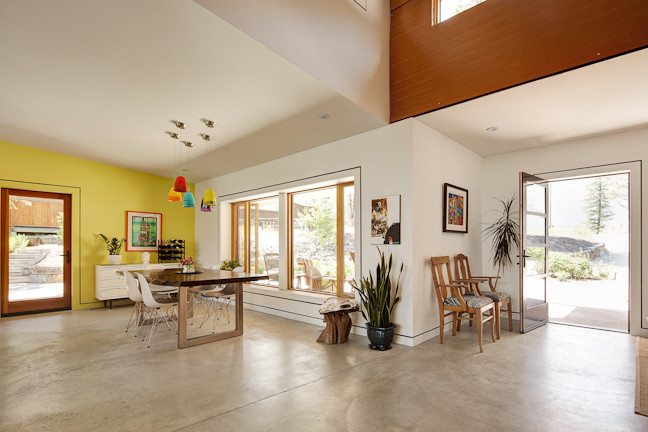 Mittelgroße Moderne Wohnküche ohne Kamin mit weißer Wandfarbe und Betonboden in Calgary