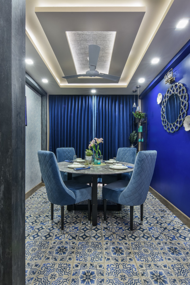 Example of a mid-sized trendy porcelain tile and multicolored floor enclosed dining room design in Bengaluru with blue walls