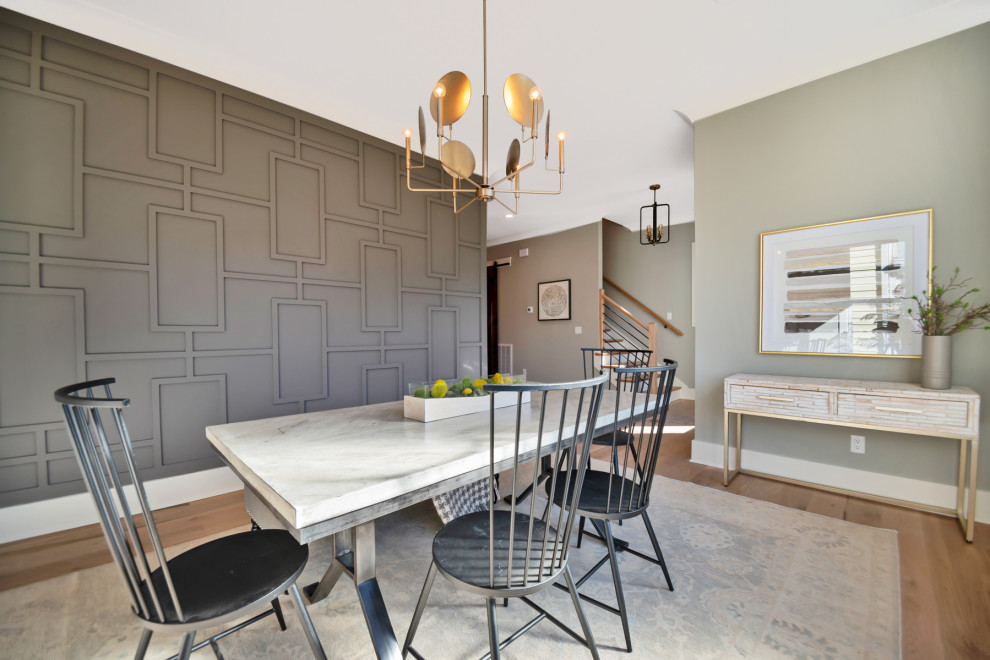 Foto di una sala da pranzo classica con pareti grigie, pavimento in legno massello medio, pavimento marrone e pannellatura