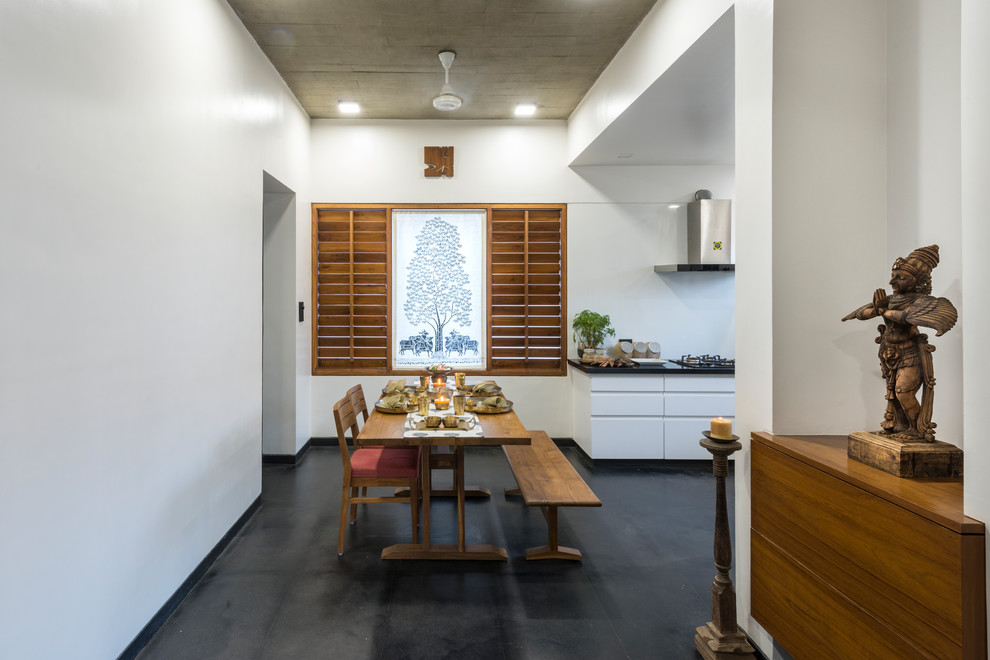 Cette photo montre une salle à manger ouverte sur la cuisine asiatique avec un mur blanc et un sol gris.