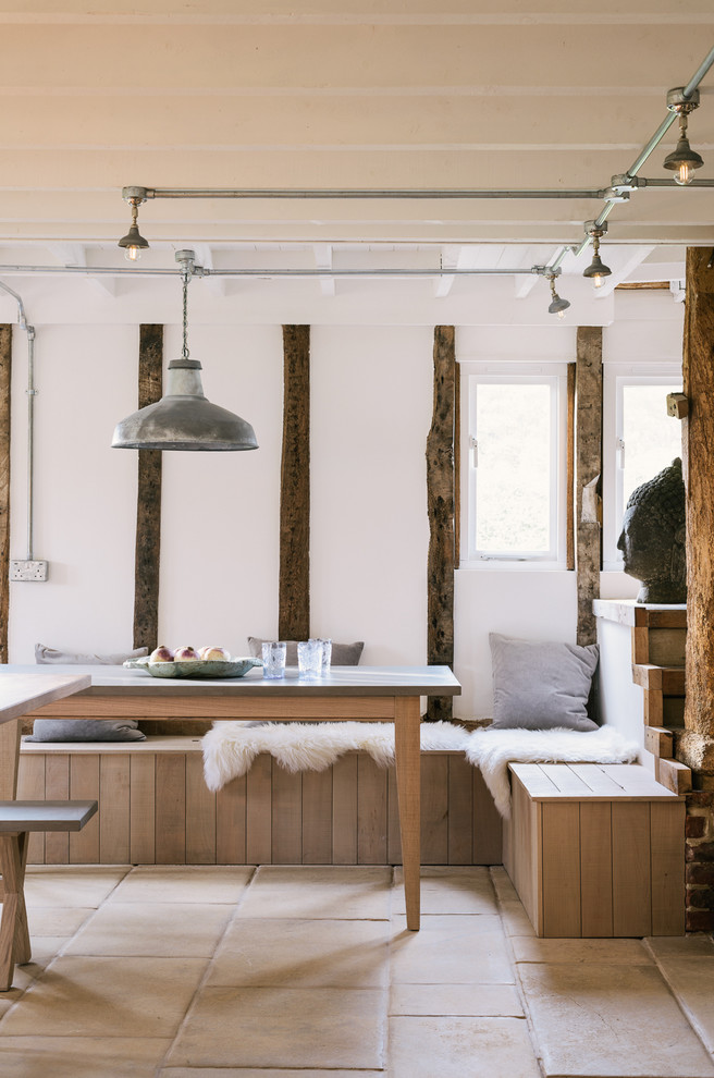 Immagine di una grande sala da pranzo aperta verso il soggiorno stile rurale con pareti bianche