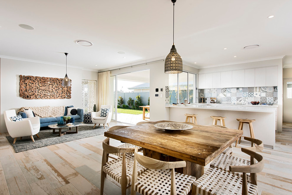 Foto di una grande sala da pranzo aperta verso la cucina costiera con pareti beige, nessun camino e pavimento in legno verniciato