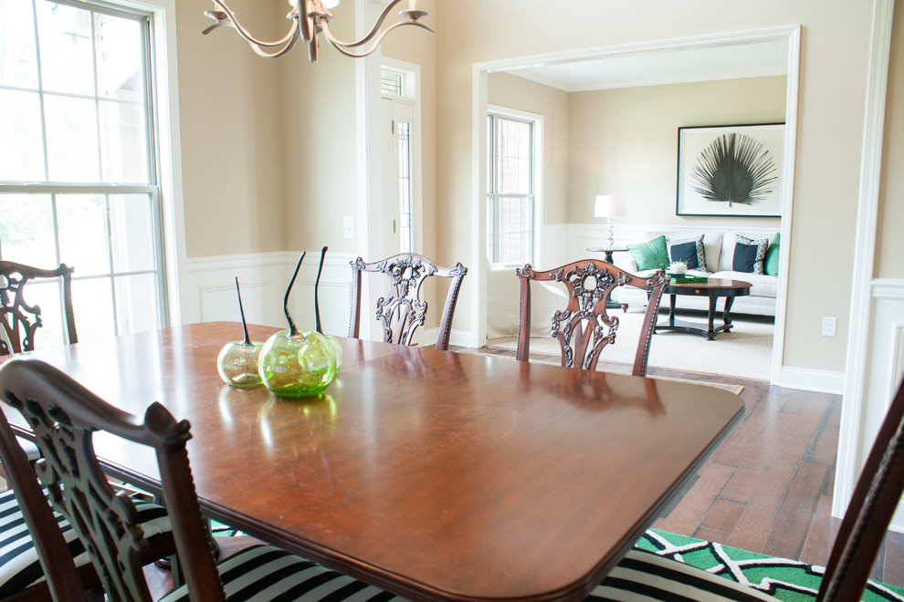 Example of a classic dark wood floor enclosed dining room design in Other with beige walls
