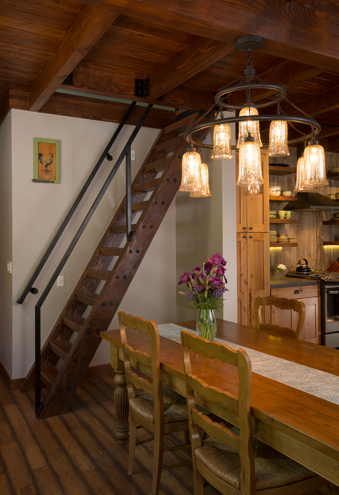 Esempio di una sala da pranzo aperta verso la cucina rustica con pareti bianche e parquet scuro
