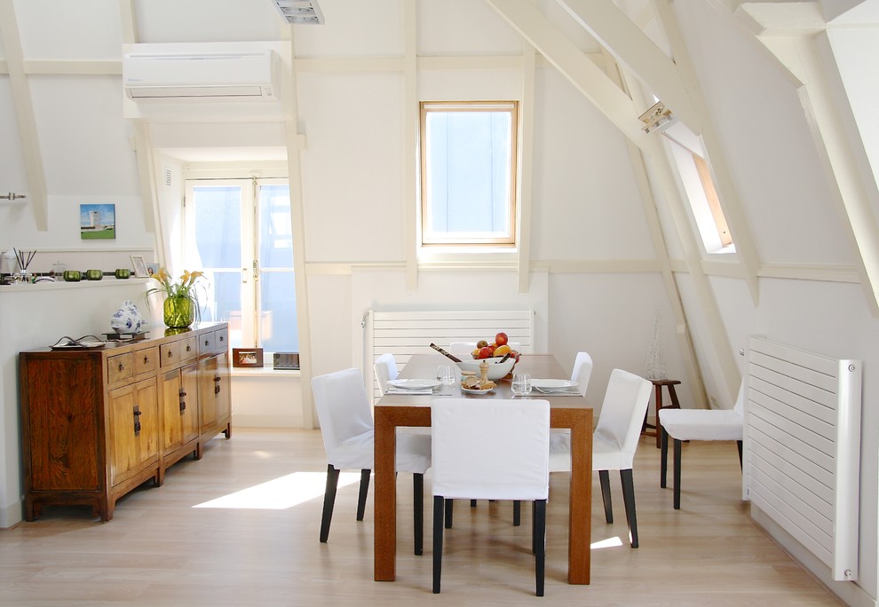 Immagine di una sala da pranzo aperta verso la cucina boho chic con pareti bianche e parquet chiaro