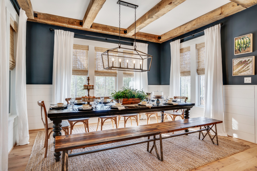 Imagen de comedor de cocina campestre grande con paredes azules y suelo de madera clara