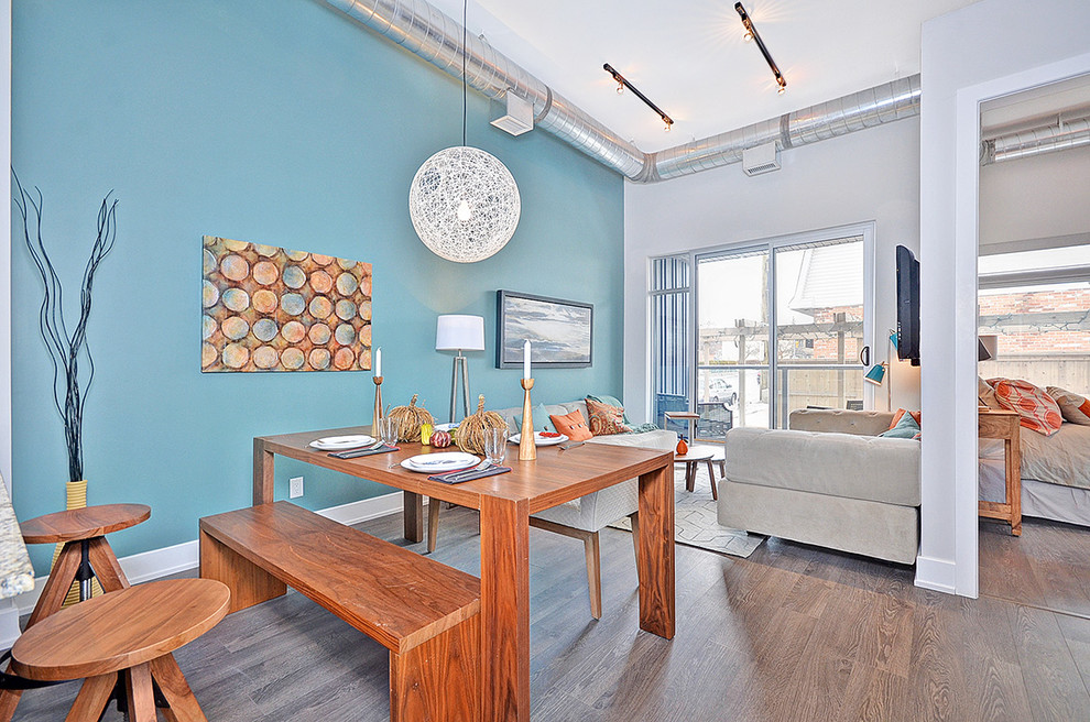 Ispirazione per una piccola sala da pranzo aperta verso la cucina minimal con pareti blu e pavimento in legno massello medio