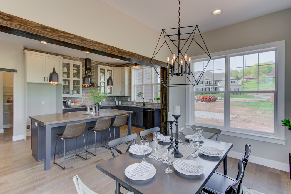 Idee per un'ampia sala da pranzo aperta verso la cucina american style con pareti marroni e pavimento in legno massello medio