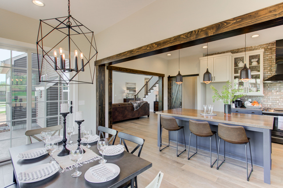 Immagine di un'ampia sala da pranzo aperta verso la cucina stile americano con pareti marroni e pavimento in legno massello medio