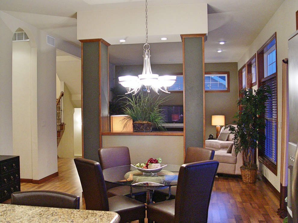 Immagine di una piccola sala da pranzo aperta verso il soggiorno classica con pareti bianche, pavimento in legno massello medio e nessun camino