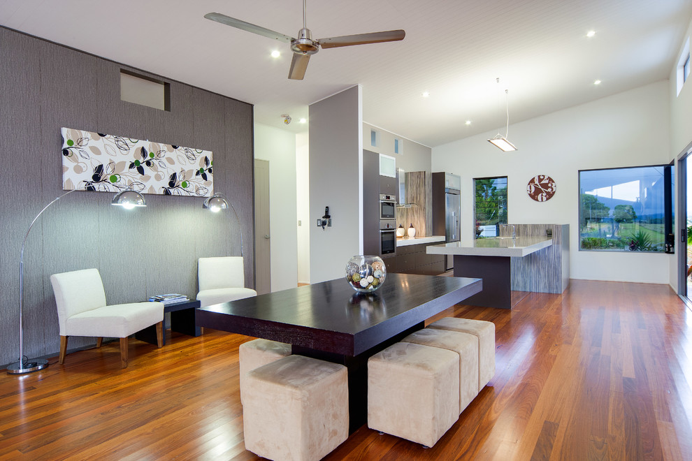 Moderne Wohnküche ohne Kamin mit weißer Wandfarbe und braunem Holzboden in Cairns