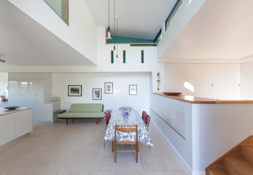 This is an example of a contemporary kitchen/dining room in Gloucestershire with white walls and porcelain flooring.