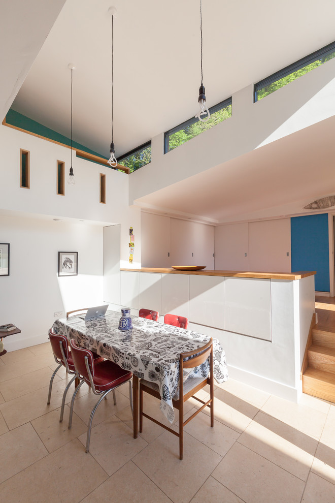 Contemporary kitchen/dining room in Gloucestershire with white walls and porcelain flooring.