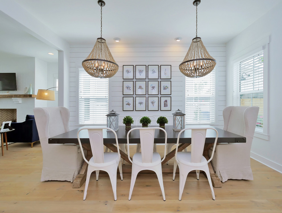 Esempio di una sala da pranzo aperta verso il soggiorno stile marino con pareti bianche, parquet chiaro e pavimento beige