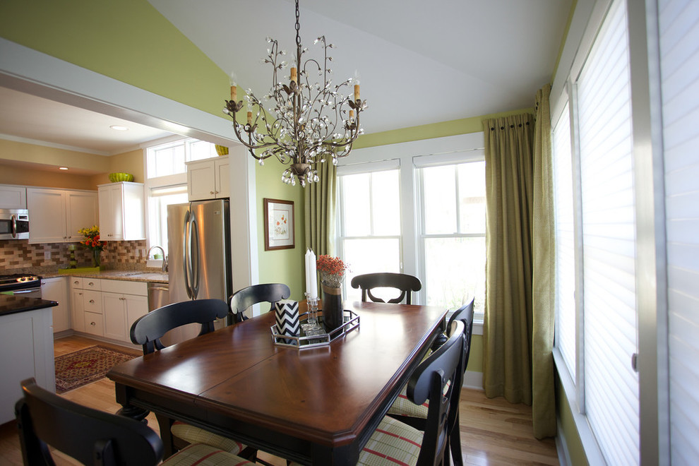 Design ideas for a classic open plan dining room in Indianapolis with yellow walls and light hardwood flooring.