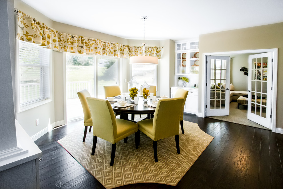 Immagine di una sala da pranzo aperta verso il soggiorno chic di medie dimensioni con pareti beige, parquet scuro, nessun camino e pavimento marrone