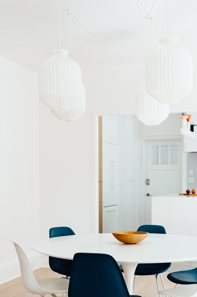 Réalisation d'une salle à manger ouverte sur la cuisine nordique de taille moyenne avec un mur blanc, parquet clair et un sol beige.