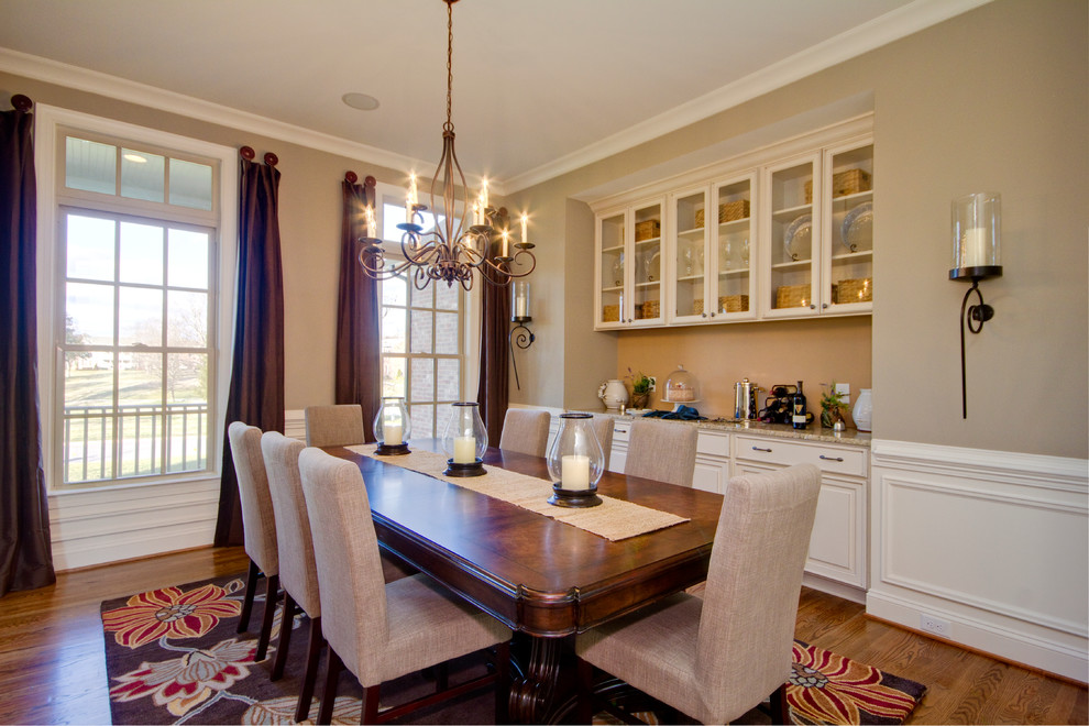 Example of a large transitional medium tone wood floor enclosed dining room design in Nashville with beige walls and no fireplace