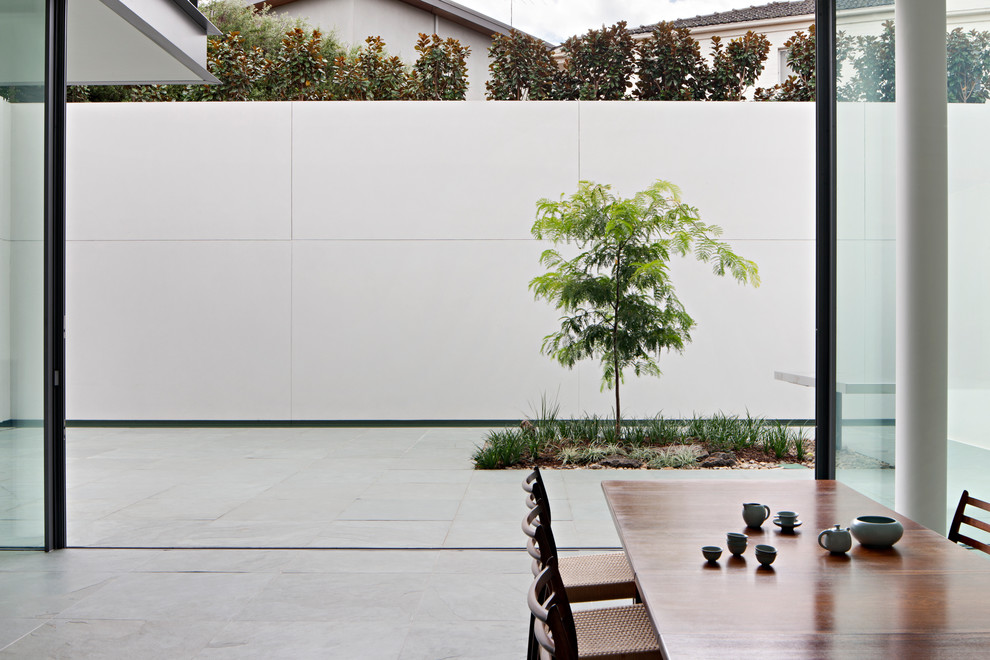 Modern inredning av en matplats, med vita väggar, skiffergolv och grönt golv