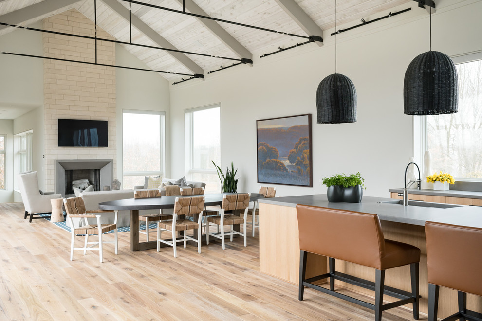 Immagine di una sala da pranzo aperta verso il soggiorno country con pareti bianche, parquet chiaro e pavimento beige