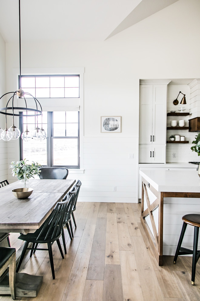 Foto di una piccola sala da pranzo aperta verso la cucina country con pareti bianche, pavimento in legno massello medio, nessun camino e pavimento marrone
