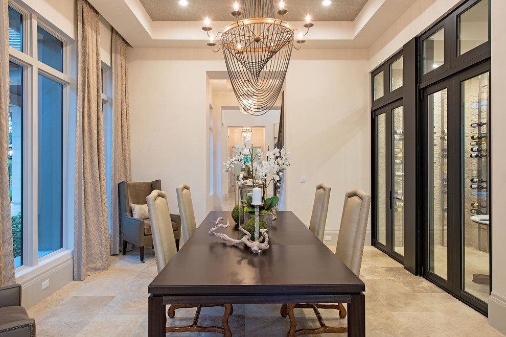 Example of a huge transitional travertine floor enclosed dining room design in Miami with white walls