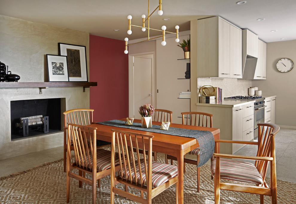 Cette photo montre une salle à manger ouverte sur la cuisine tendance avec un mur rouge, un sol en carrelage de céramique, une cheminée standard, un manteau de cheminée en plâtre et un sol noir.