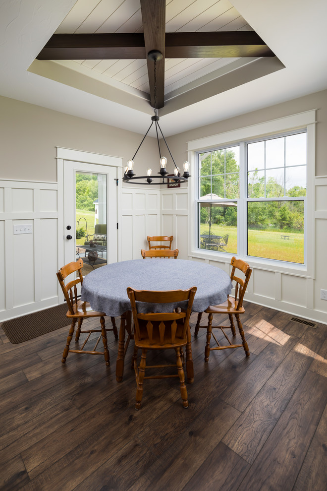 Cette image montre une salle à manger ouverte sur la cuisine traditionnelle de taille moyenne avec un mur beige, sol en stratifié et un sol marron.