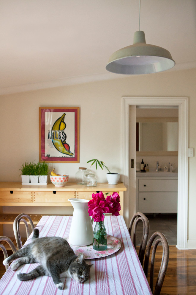 Immagine di una piccola sala da pranzo aperta verso la cucina boho chic con pareti beige e parquet scuro