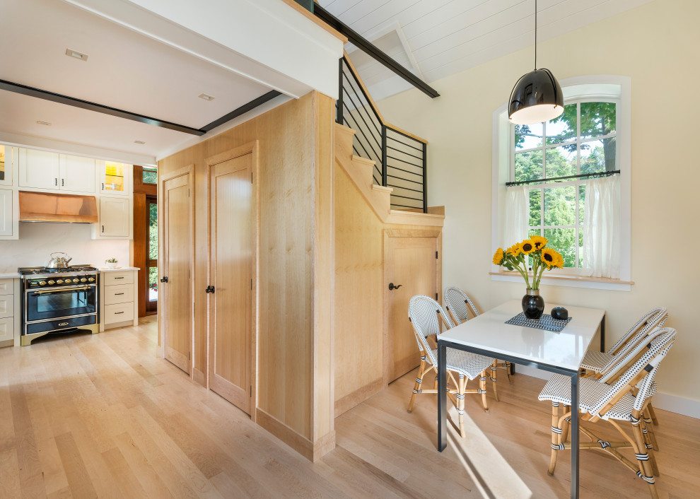 Idee per una piccola sala da pranzo aperta verso il soggiorno industriale con pareti bianche, parquet chiaro e pavimento beige
