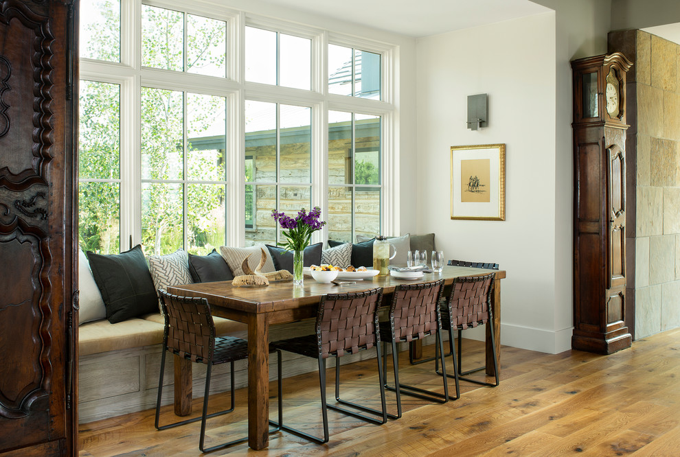 Idee per una sala da pranzo aperta verso la cucina rustica con pareti bianche, pavimento in legno massello medio e pavimento marrone