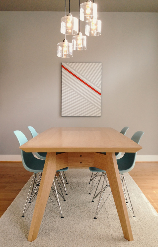 Cette image montre une salle à manger minimaliste avec un mur gris et un sol en bois brun.